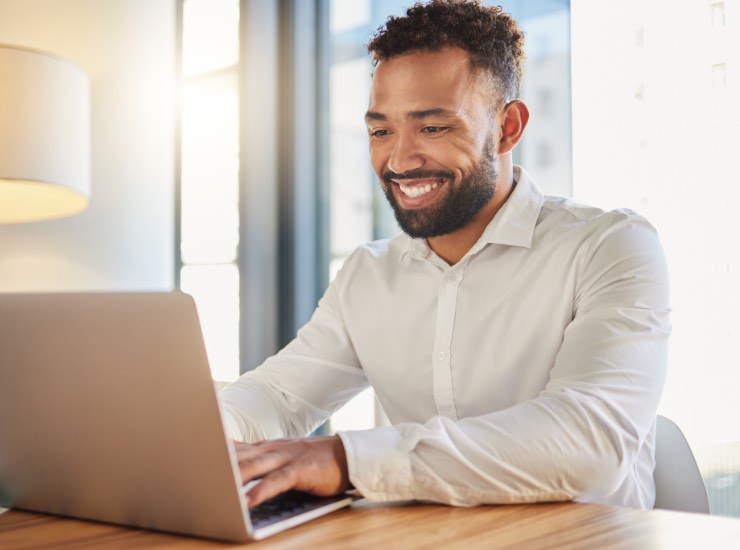 Un ragazzo sorride davanti al pc